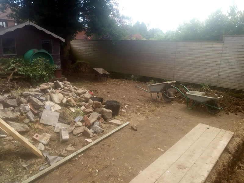 sketty garden with grass removed large pile of rubble on the left